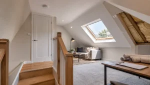 Modern loft conversion interior with skylight window, staircase, and seating area designed to meet building regulations on loft conversions for safe and compliant attic renovations.